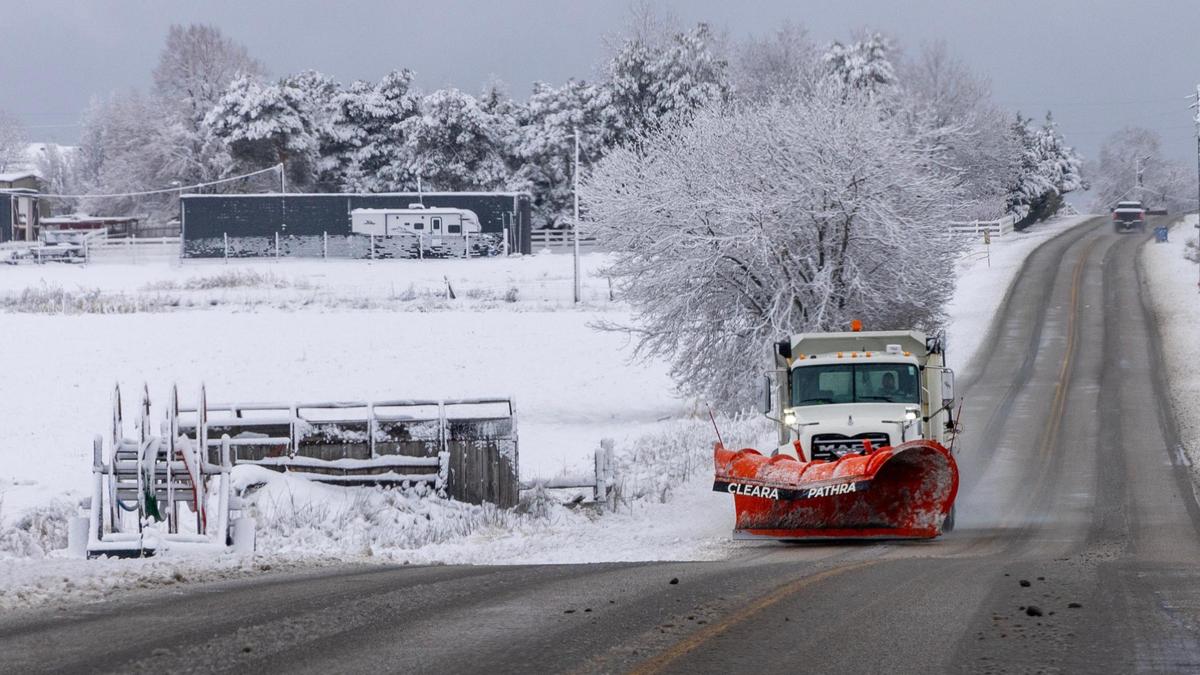 A truck lays snow melt on Locust Grove Road in Meridian on Friday.