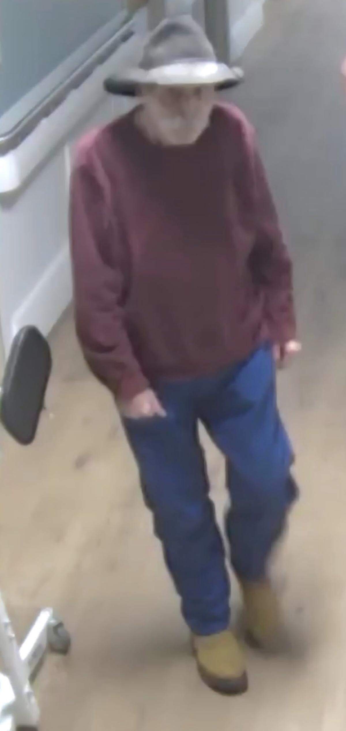 The man was wearing a maroon sweater, jeans and yellow boots.