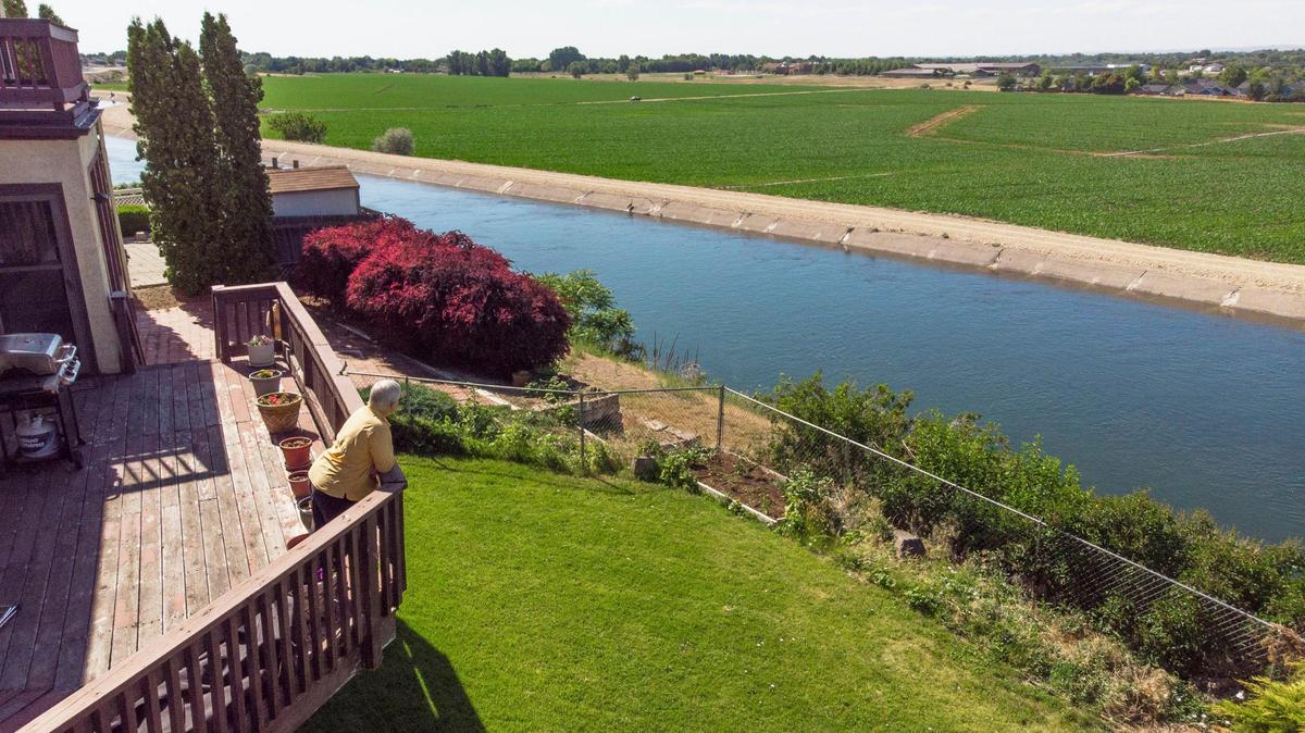 Paula Triplett looks out from her South Boise home’s balcony overlooking the New York Canal and a 160-acre parcel of land that the City of Boise has long planned to develop into Murgoitio Park. The plan changed with land swap deal that would trade most of the parcel with a developer for land in the Boise Foothills. Instead of a park with trees and pathways, Triplett says she will likely be looking at a sea of dense housing.
