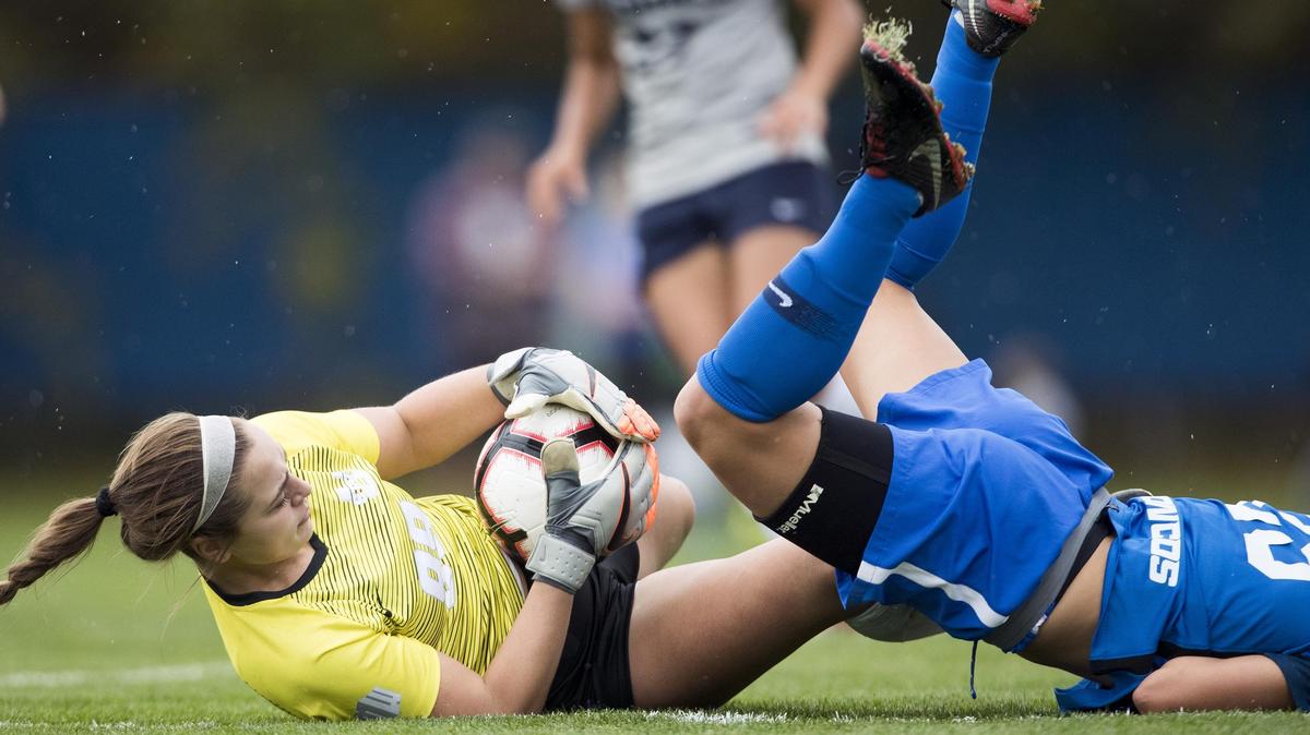 Boise State midfielder McKenna Kynett topples over the top of Utah State keeper Grace McGuire as she secures the ball Friday at the Boas Soccer Complex in Boise. McGuire held BSU to only one goal in the Mountain West game, and the Aggies broke through for a 2-1 win in double overtime.