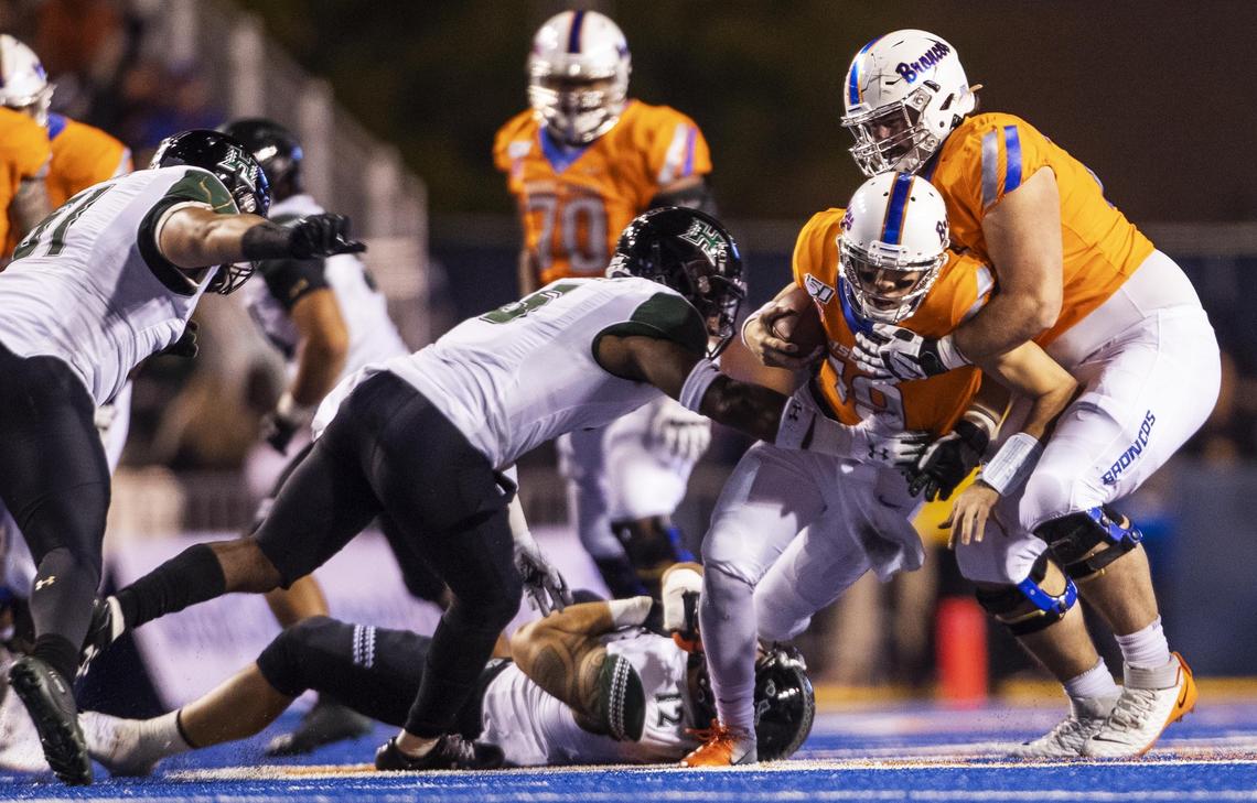 Boise State quarterback Hank Bachmeier (gets a little help moving the football up field from offensive lineman John Molchon against Hawaii on Saturday at Albertsons Stadium.