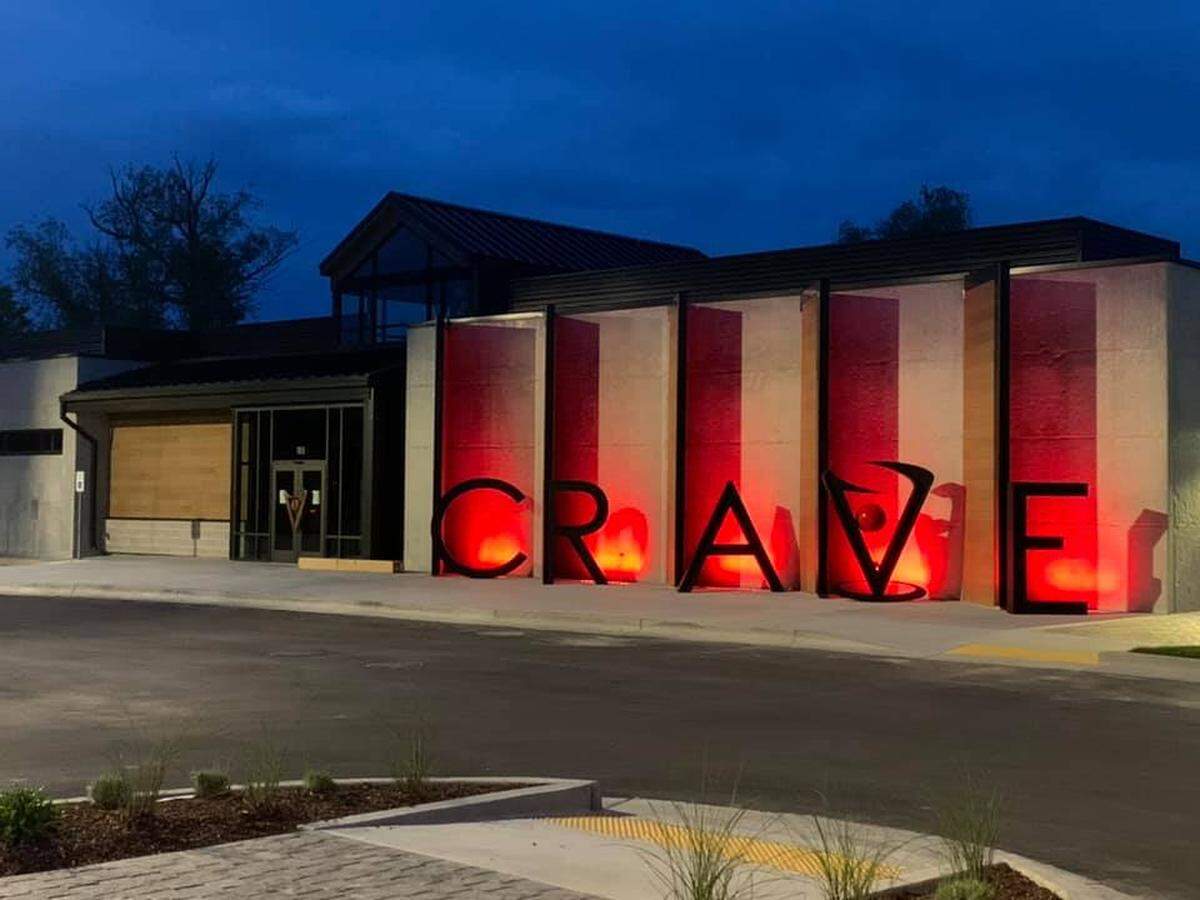 The letters light up at night outside Crave Kitchen & Bar