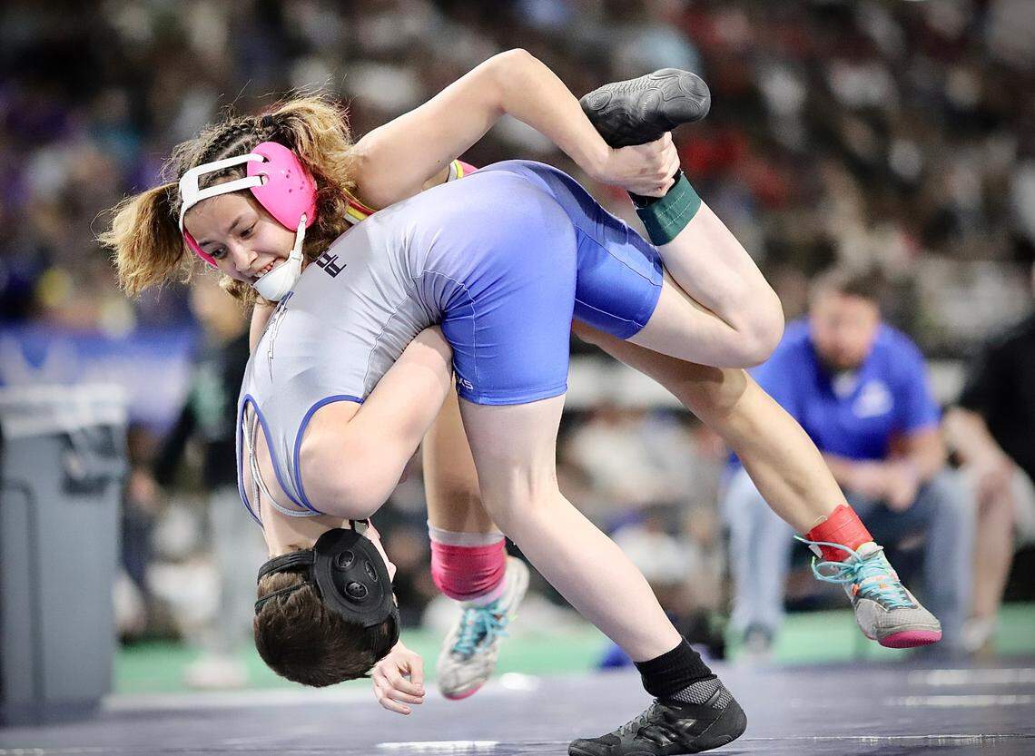 Caldwell’s Nia Avelino drives Thunder Ridge’s Mia Reagan into the mat Saturday during their state championship bout at the ICCU Dome in Pocatello.