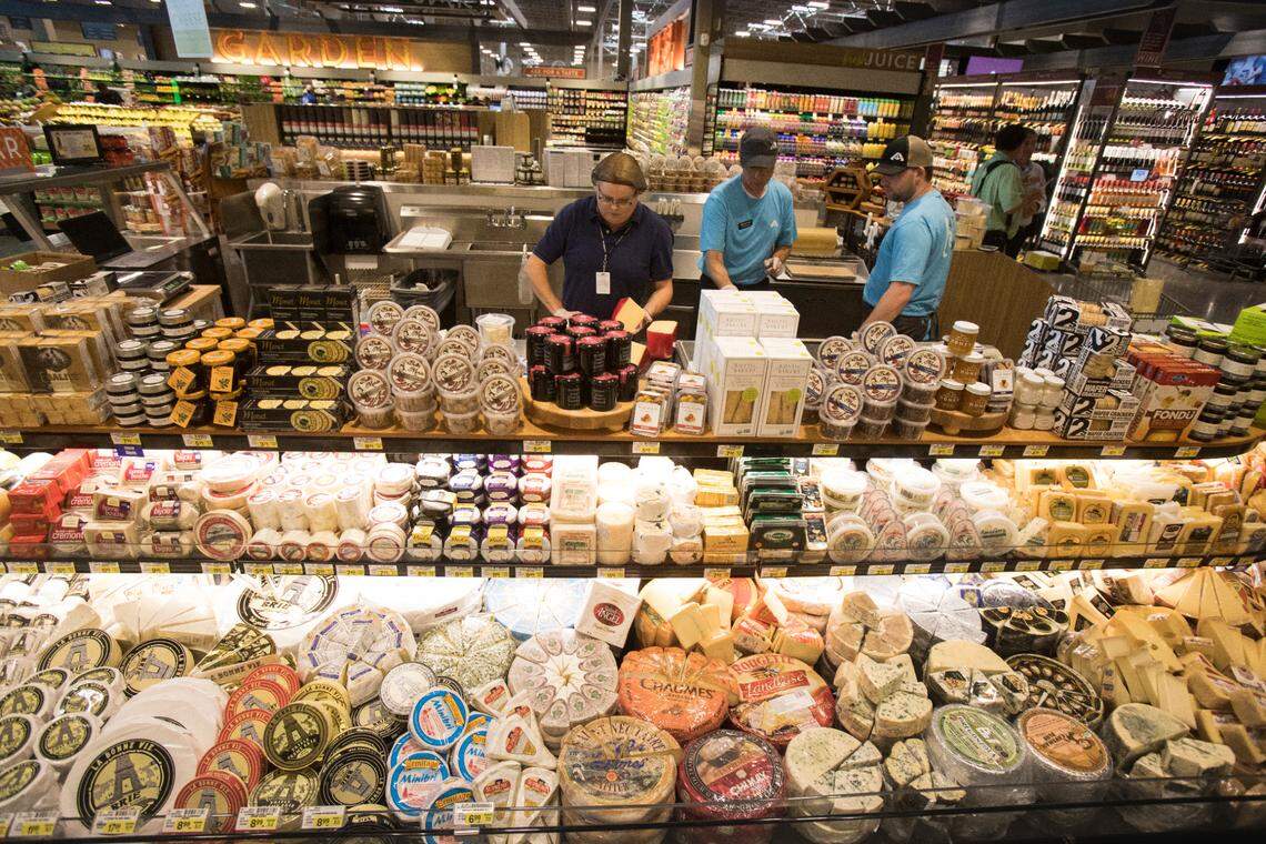 Jackie Harmon, center, from Gourmet Foods International, cuts a wheel of Van Kaas Gouda cheese at the Albertsons store on Broadway Avenue.