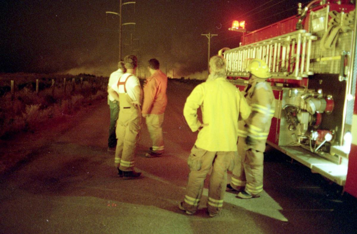 Firefighters watch as flames from the Initial Point Fire spread rapidly southwest of Kuna on July 28, 1995. Two Kuna firefighters, Bill Buttram and Josh Oliver, died while fighting the fire.