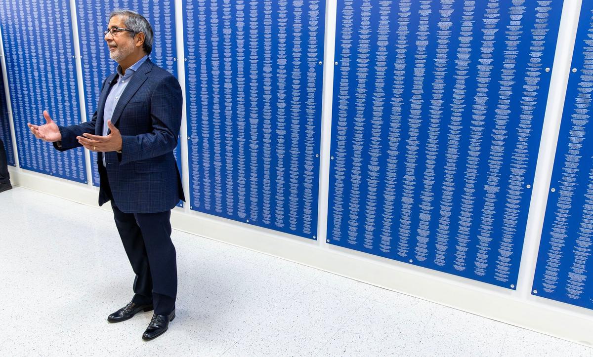 Micron CEO Sanjay Mehrotra stands in front of a wall showing over 50,000 patents.