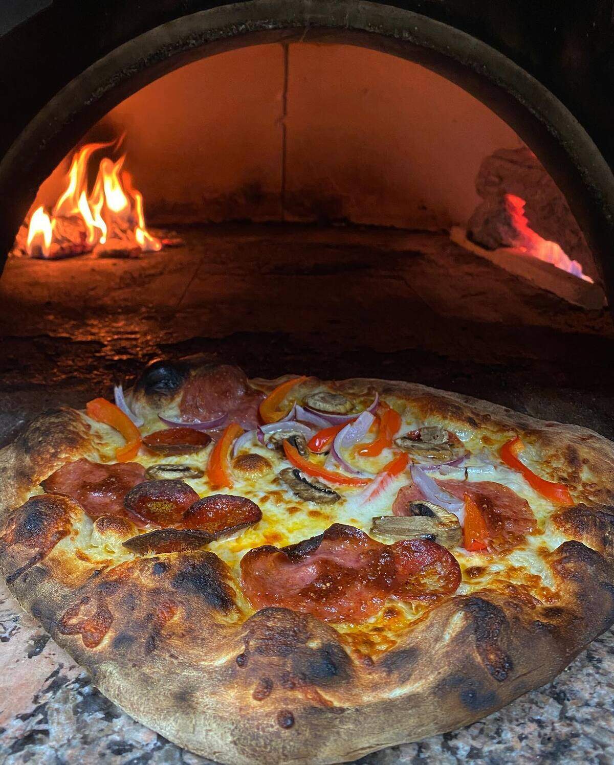 Alpine Pizza blisters its pies in a wood-fired brick oven.