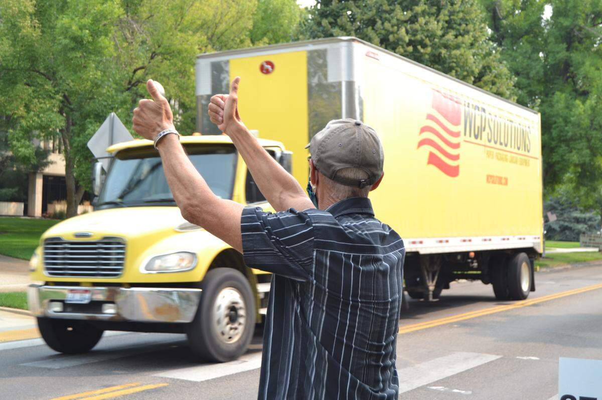 Marshall Brezonick gives the thumbs-up to a passing commercial truck honking its horn Monday during the State Street Demonstration for American Values at the Idaho State Capitol. “I believe our country is at an inflection point,” Brezonick said of his reason for demonstrating.