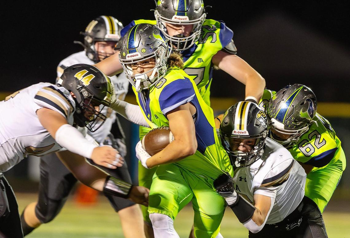 Mountain View senior wide receiver Grayson Flatten fiths through a pair of Kuna tacklers in a 52-15 win on Friday.