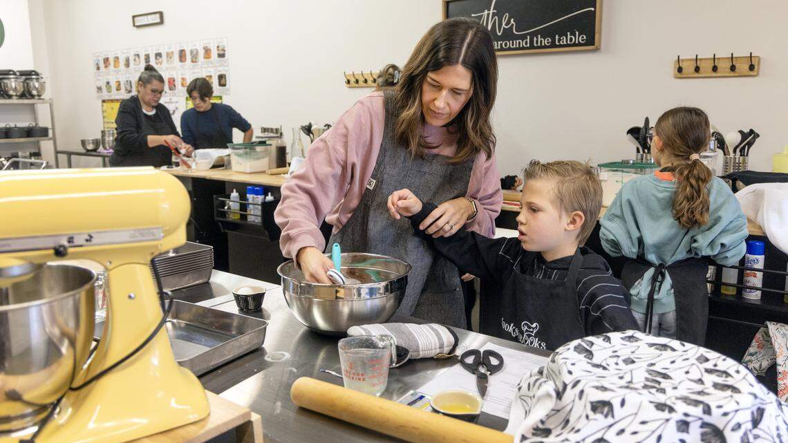 Lauren Bettger and her son Houston Bettger, 7, prepare dough for cinnamon rolls during a cooking class at Cooks and Books in Meridian, Wednesday, Nov. 26, 2025. Cooks and Books is a new bookstore that features a curated selection of cookbooks and as well as offering cooking classes and book clubs.