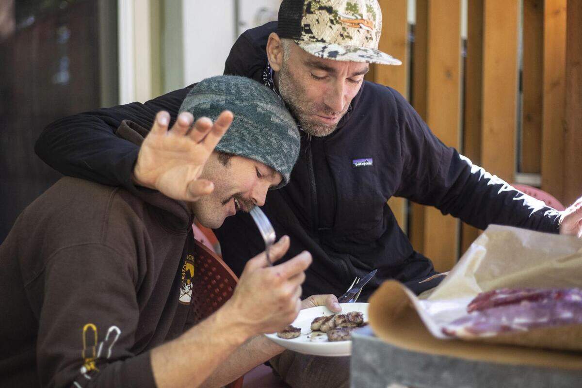Hagood and Glenn share the first taste of backstrap meat while processing a mountain goat at Glenn’s home. Each volunteer was allowed to pack out meat from one goat and donate any additional salvageable meat. Trophy parts of the goats, including heads, horns and hides, were to be left in the Tetons.