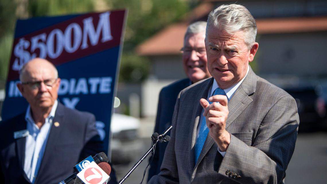 Idaho Gov. Brad Little, flanked by a delegation of lawmakers, in Boise on Aug. 23, 2022.