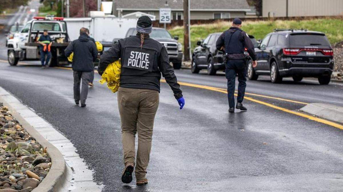 Idaho State Police and other investigators pack up police tape as they prepare to open the roundabout at Thain Road and Powers Avenue in Lewiston after a shooting.