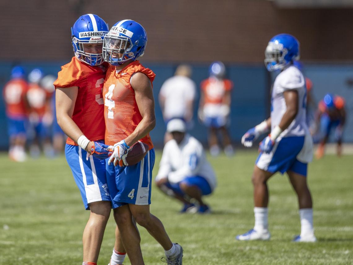 Boise State safety DeAndre Pierce celebrates an interception with teammate Demitri Washington during the Broncos’ fall camp Friday, Aug. 2, 2019.