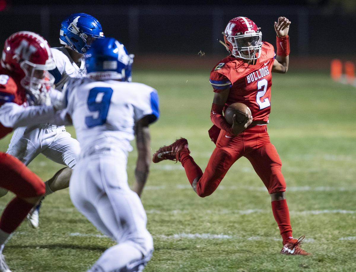 Nampa quarterback Donavon Estrada looks for running room around Emmett’s defense on Oct. 25.