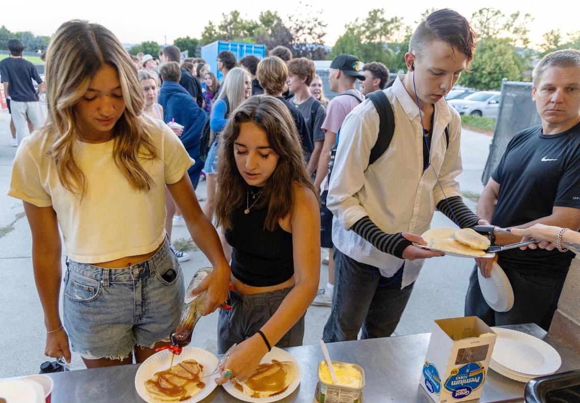 Seniors including Joie Charles, left, and Jenna Welle, second from left, stand in line at the second annual Senior Sunrise Breakfast at 6:30 a.m. Wednesday on the first day of school at Timberline High School.