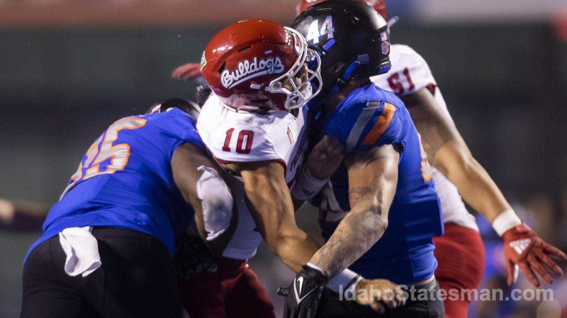 Boise State edge George Tarlas and defensive tackle Divine Obichere crunch Fresno State quarterback Logan Fife after he gets a pass off, Saturday, Oct. 8, 2022, at Albertsons Stadium in Boise.