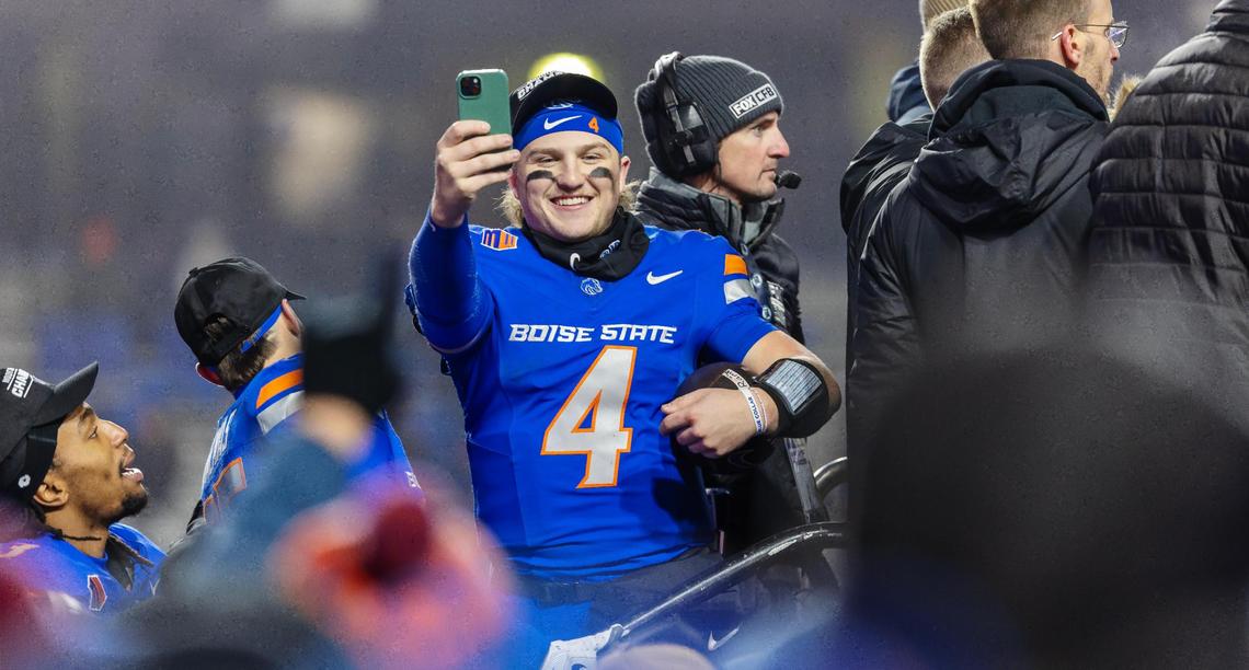 Boise State quarterback Maddux Madsen takes photos with a fan’s phone from the awards podium after Boise State’s win in the Mountain West championship game against UNLV.