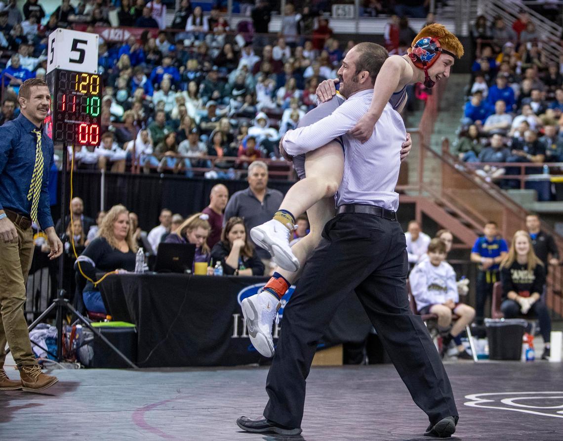 Meridian’s Cade White is hoisted high by assistant coach Jon Muri after upsetting Caden Ramos, Thunder Ridge, in double overtime and winning the 5A 120-pound state wrestling championship Saturday, Feb. 29, 2020 at Ford Idaho Center in Nampa.