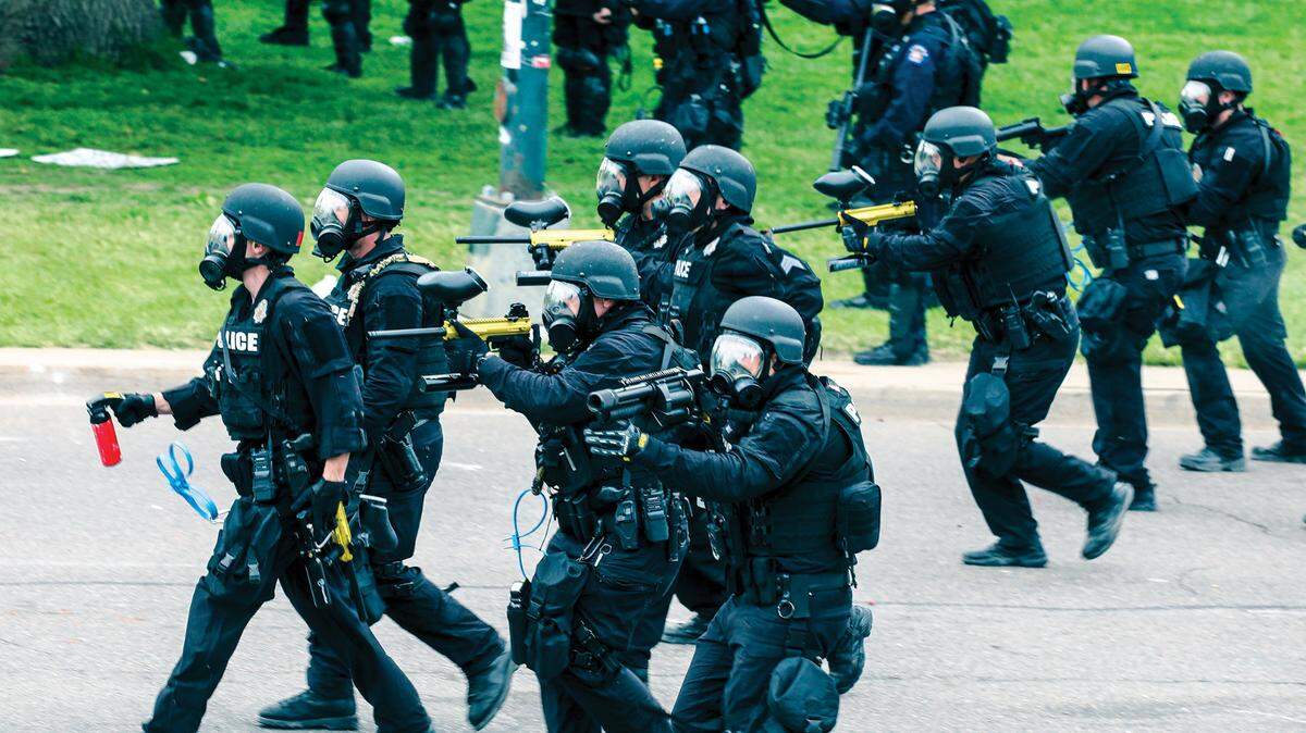 Police in Denver use PepperBall launchers to quell Black Lives Matter demonstration in 2020. The officer in the foreground is using a beanbag launcher. The others hold PepperBall launchers. 