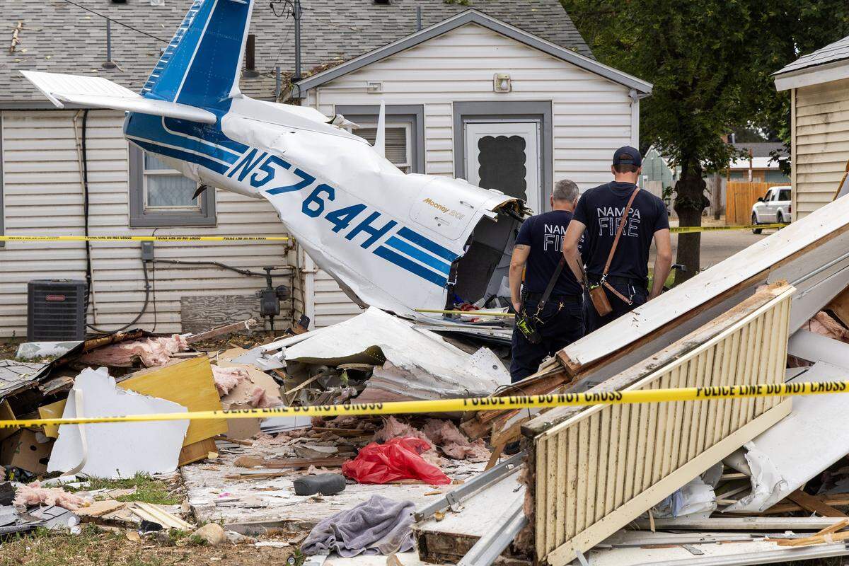 Nampa firemen look over the crash site in a Nampa neighborhood, Monday, July 28, 2025, where plane crashed into a shed on Sunday, killing three people aboard the plane. The plane crashed into a shed behind a home at 203 N. Venice Street.