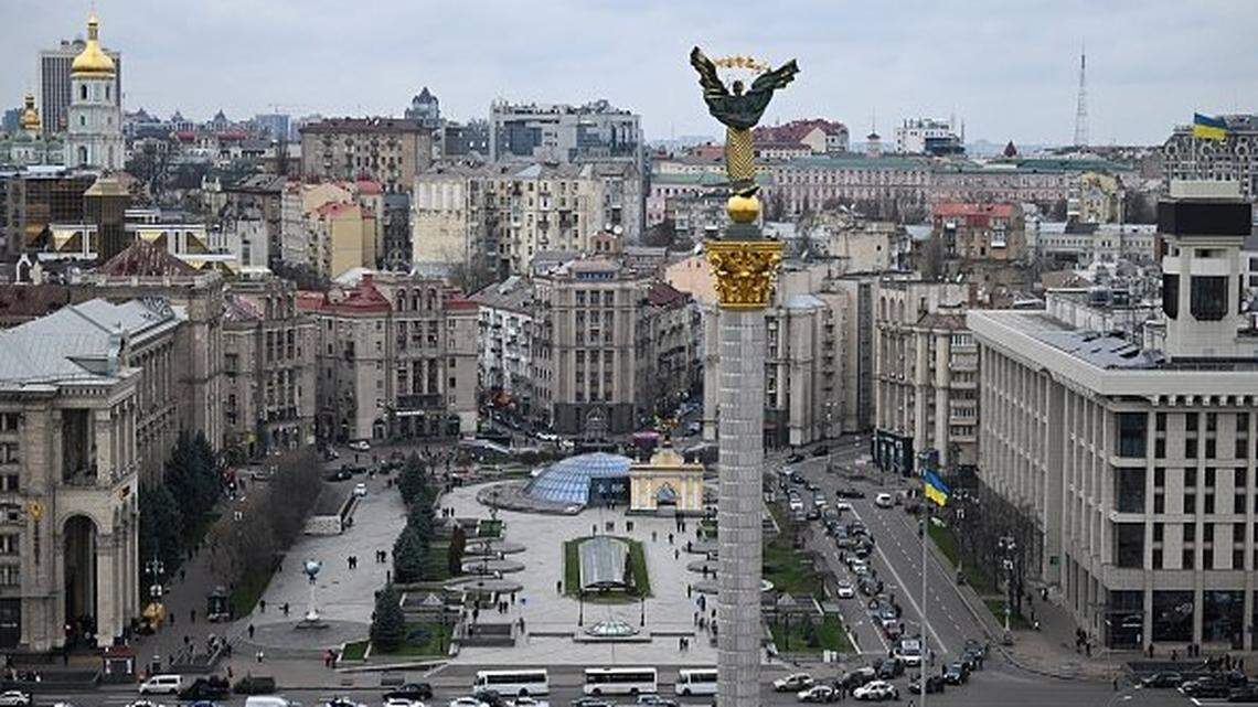 Pedestrians and drivers observe a minute of silence as the body of a slain Ukrainian soldier is carried in a hearse past Independence Square, in Kyiv, on November 24, 2025, amid the Russian invasion of Ukraine. Ukrainian President Volodymyr Zelenky on November 24, 2025 hailed "important steps" after talks in Geneva with the US, but said more work is needed to negotiate an end to the war with Russia. (Photo by Sergei GAPON / AFP via Getty Images)