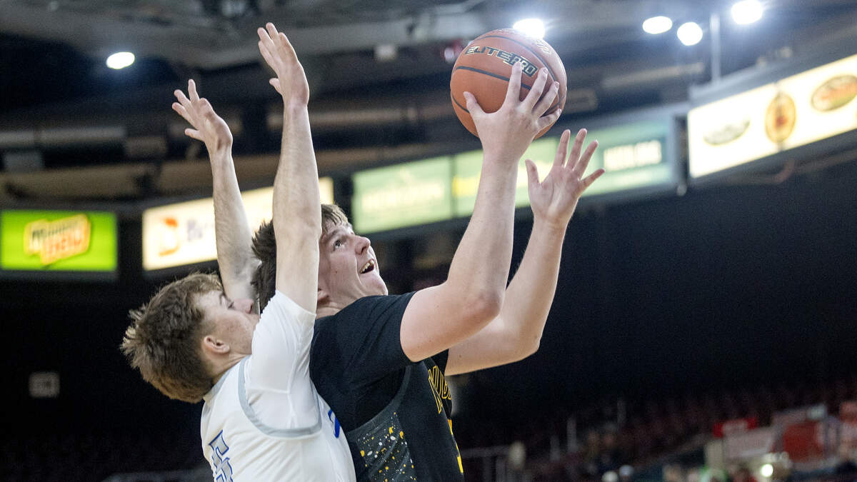 Bishop Kelly senior Andrew Johnson gets past Preston senior Branson Smith to score during their 5A boys basketball state tournament semifinal game Friday at the Ford Idaho Center in Nampa. Bishop Kelly won 63-60 in overtime.