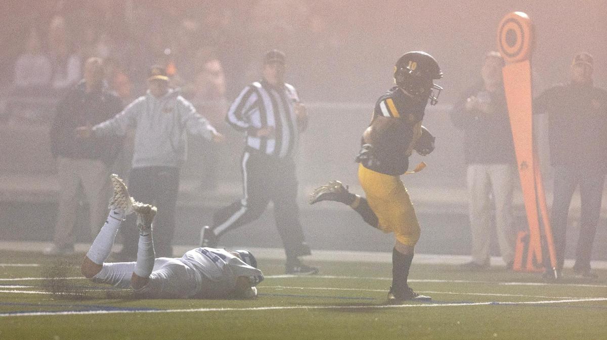 Bishop Kelly’s Crew Nelson hits the edge for an 18-yard touchdown run against Emmett on Friday.