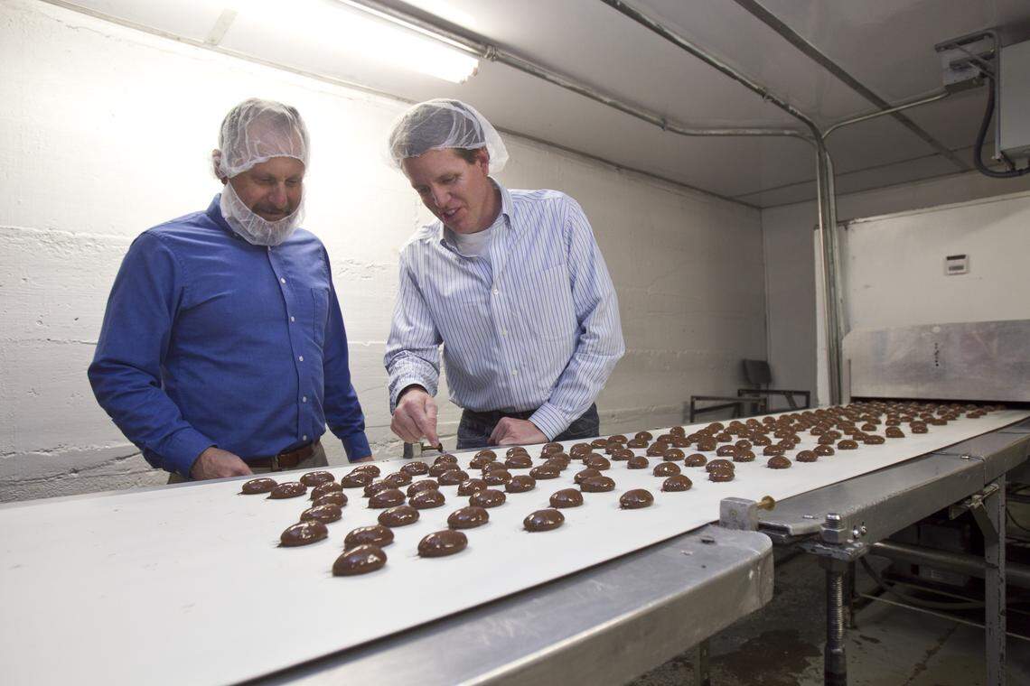 Consultant Jeff Kronenberg, left, listens as Dave Wagers, president of Idaho Candy Company, talks about one of the lines at the company’s plant.