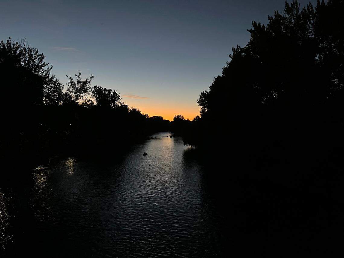 People raft down the Boise River in late September as the sun sets.