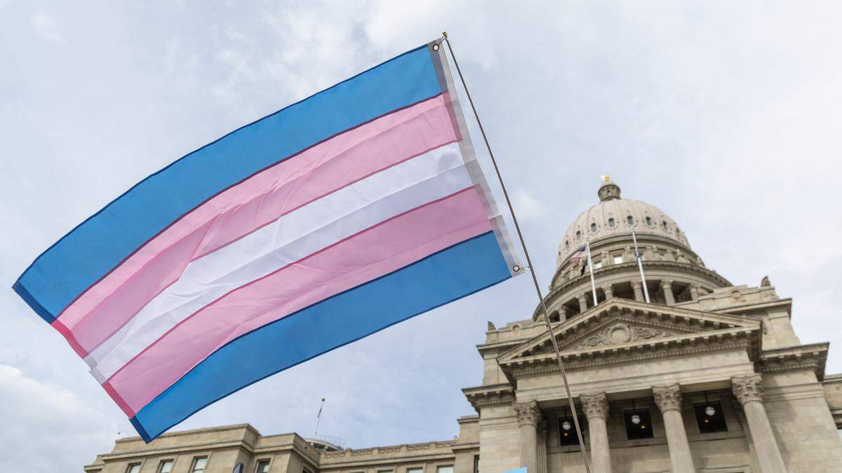 A person flies a transgender pride flag outside of the Idaho Capitol in Boise during a Trans Day of Visibility rally, Tuesday, March 31, 2026.