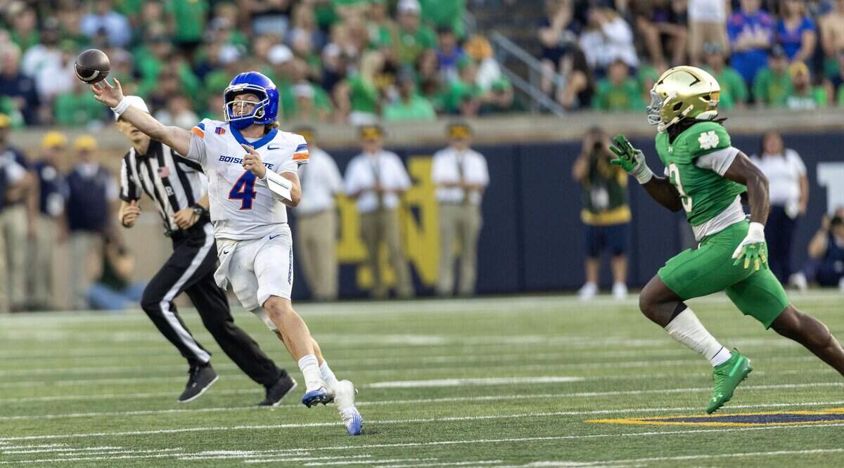 Boise State quarterback Maddux Madsen scrambles and throws on the run as Notre Dame linebacker Jaylen Sneed chases in South Bend, Ind., Saturday, Oct. 4, 2025.