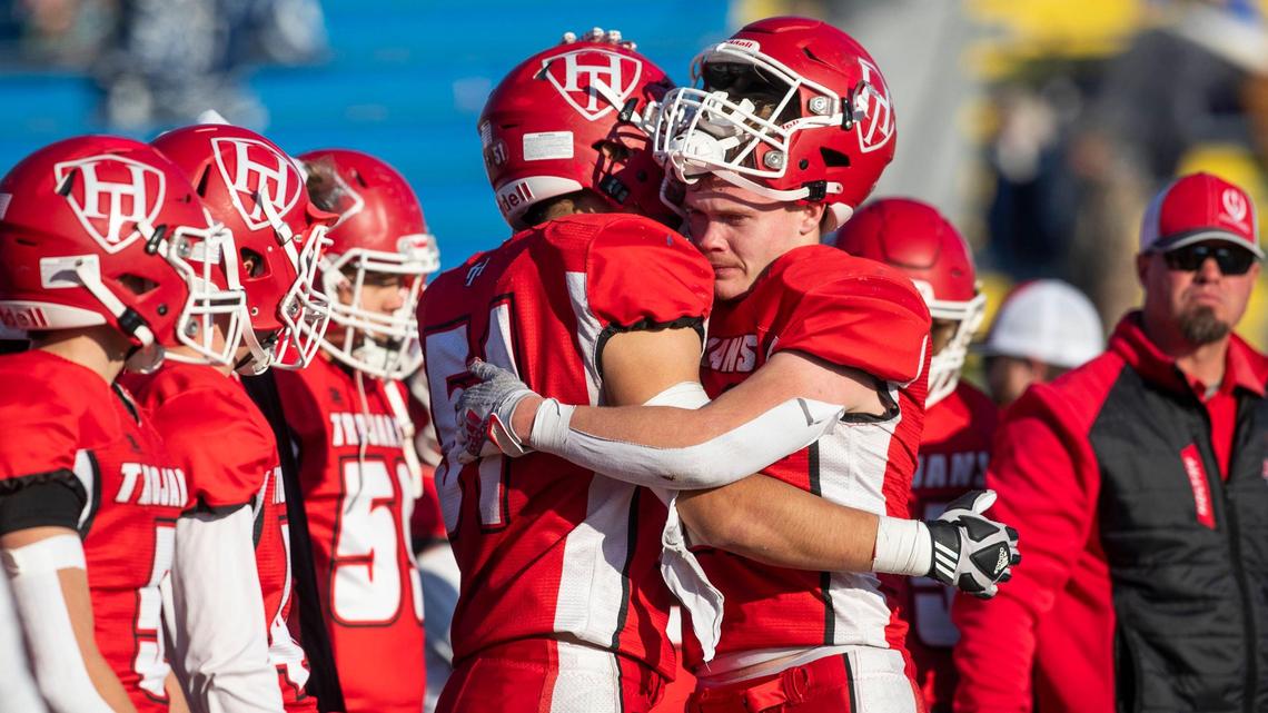 Homedale seniors Trenton Fisher, right, and Omar Rios end their season with a hug after receiving the 3A state runner-up trophy. Sugar-Salem topped Homedale 20-15 in the 3A state championship Saturday at Middleton High.