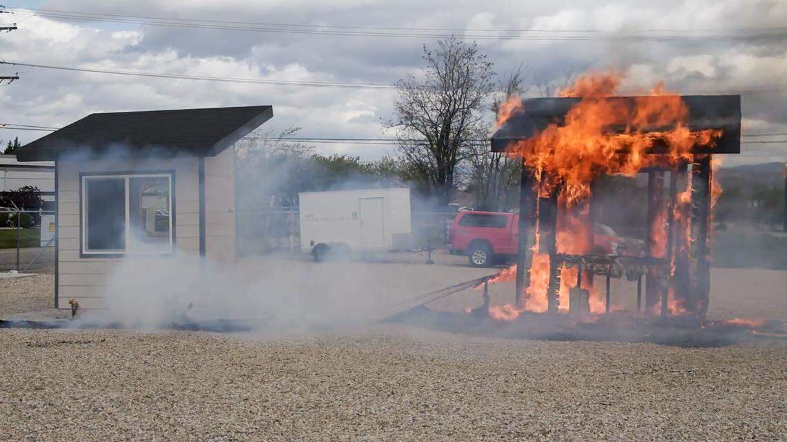 At a burn demonstration, the fire at the model home on the left — outfitted with fire-resistant landscaping — burned out within a few minutes. The home on the right, in contact with bushes, a tree and a wooden fence, was consumed by flames and ultimately collapsed.