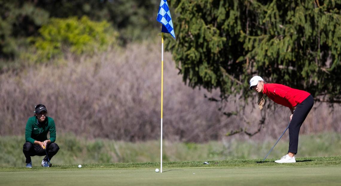 Boise senior Emily Cadwell, right, watches her putt stop shy of the first hole with Eagle’s Brooke Patterson on Monday at Warm Springs Golf Course during the 5A District Three girls golf tournament.