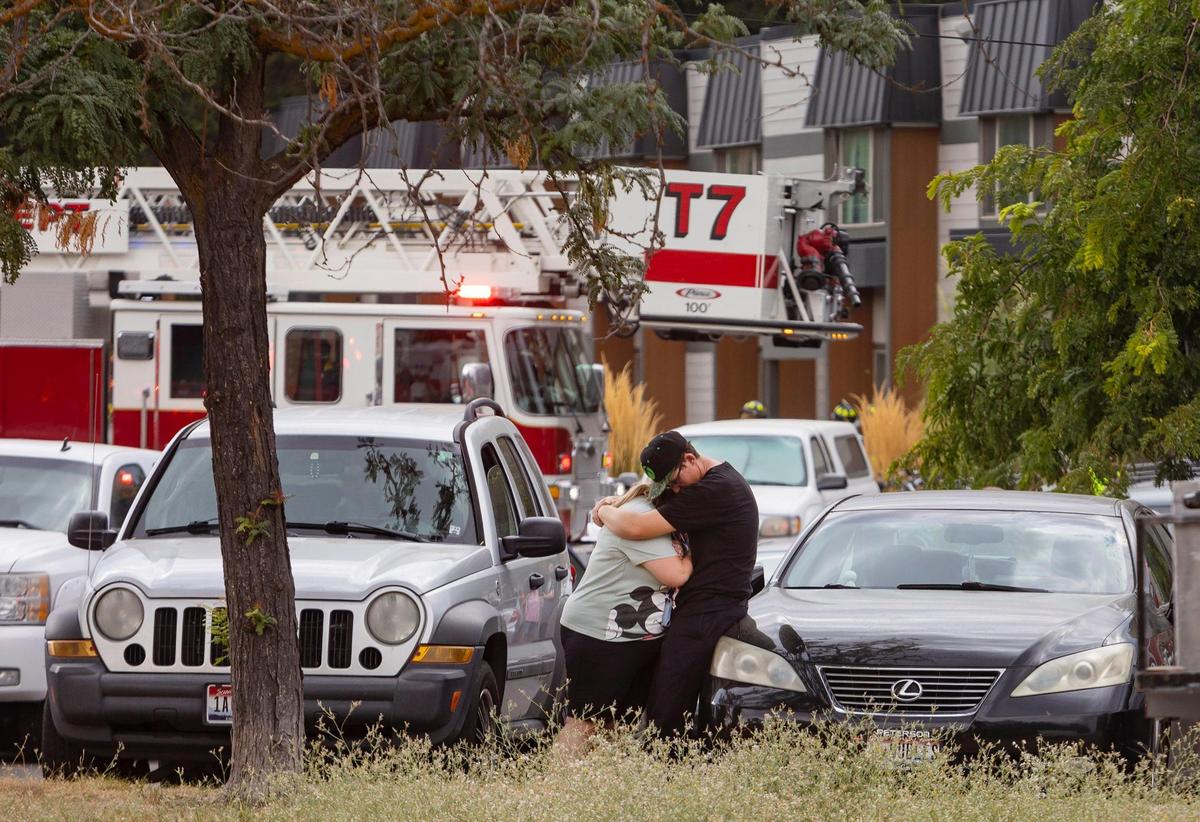 People embrace in the parking lot of Creek Bend Apartments, 1140 Colorado Lane in Boise, as fire crews work to put out a fire inside the structure on Wednesday evening.