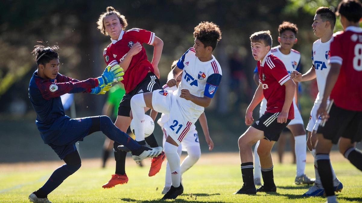 Boise Timbers’ Grayson Carter, center left, forces the ball past Total Futbol Academy’s goalkeeper Kevin Rafael in the U-14 boys championship game Sunday at the U.S. Youth Soccer Far West Regionals at the Simplot Sports Complex in Boise.
