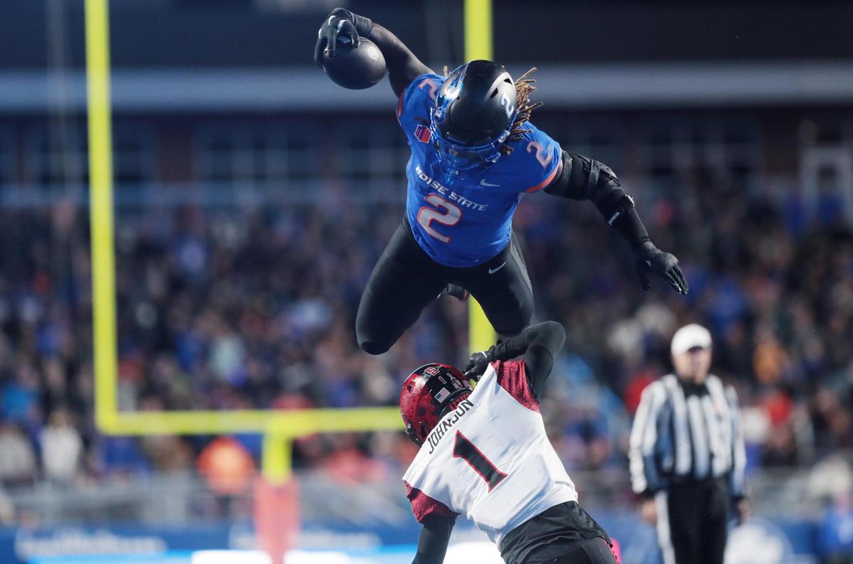 Boise State running back Ashton Jeanty leaps over San Diego State cornerback Chris Johnson during the second half of the game. Boise State defeated San Diego State 56-24 at Albertson’s Stadium in Boise, Idaho.