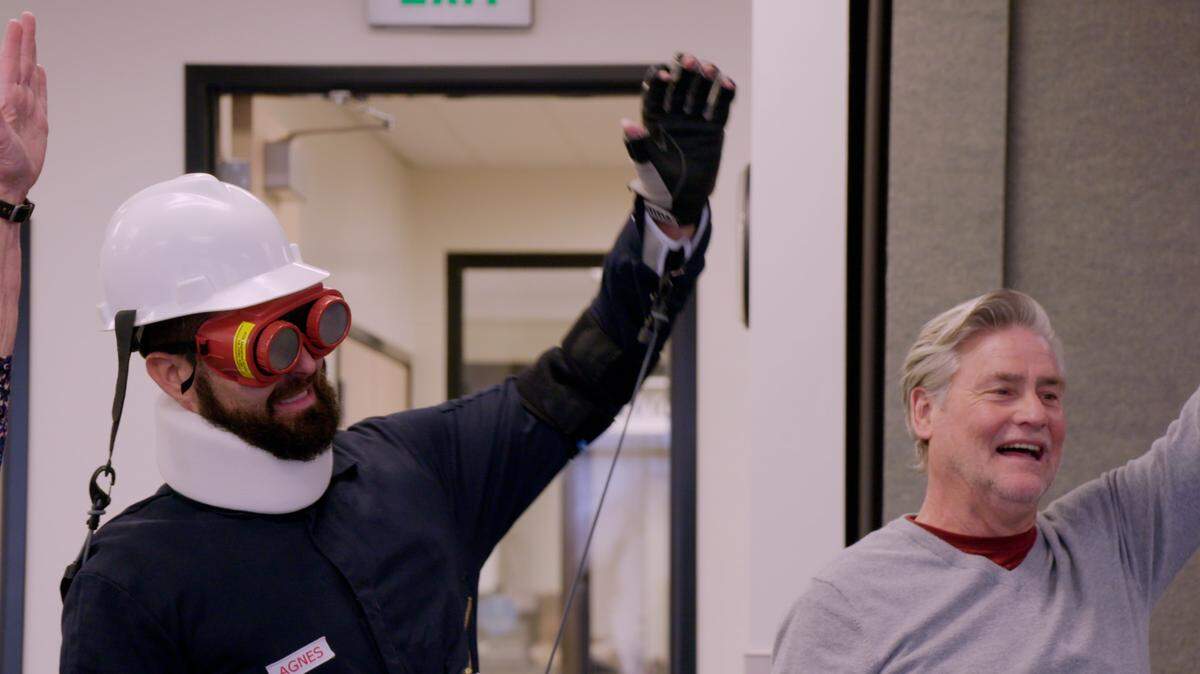Drey Campbell, left, wears an MIT aging suit while attending a Fit and Fall class for older adults in Caldwell with his father, Roger, right.