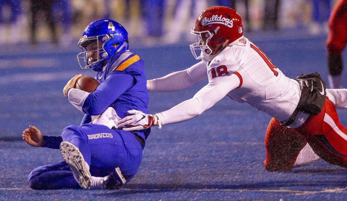 Boise State quarterback Brett Rypien (4) slide for a first down against defense by Fresno State defensive lineman Isaiah Johnson (18) during the Mountain West Championship game at Albertsons Stadium. Boise State trails Fresno State 7-10 at the half. Saturday December, 01, 2018.