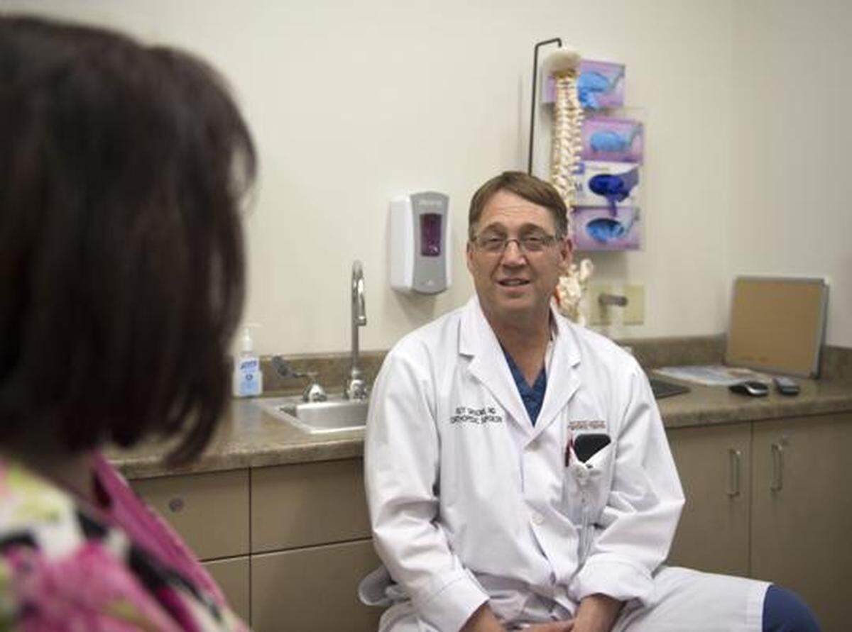 Dr. Guy Grooms meets with a patient July 17 at North Canyon Medical Center in Gooding.