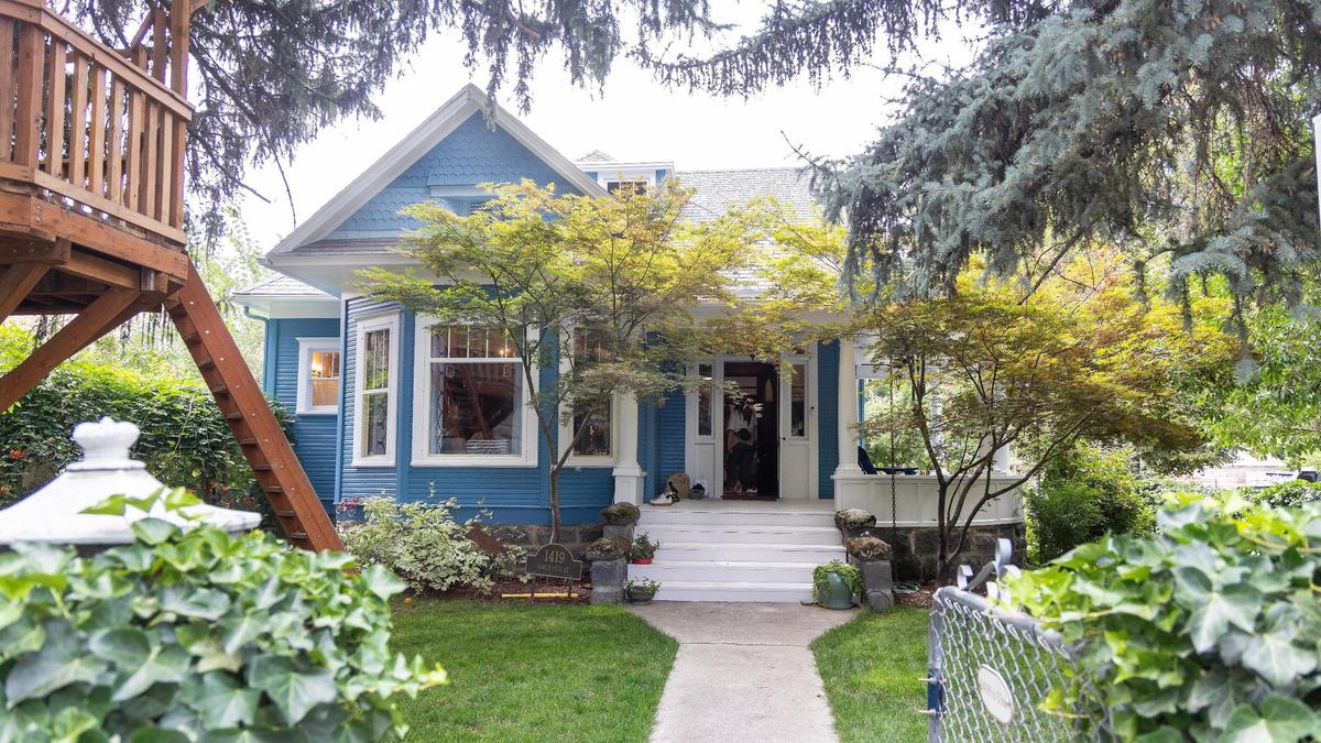 The house at 1419 N. 13th St. has a large front porch that wraps around the right side with two stairways.