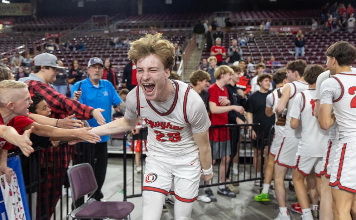 Owyhee’s Boden Howell celebrates with students after the Storm crushed Lake City 77-46 for the 6A boys basketball state title Saturday at the Ford Idaho Center in Nampa.
