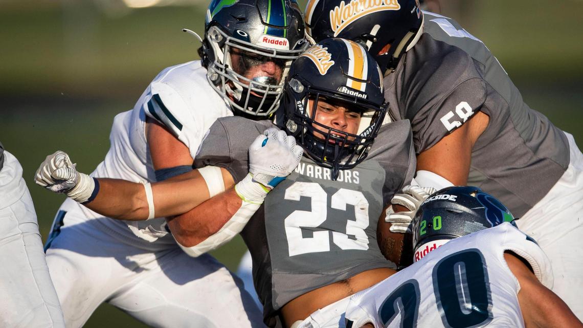Meridian running back Marco Del Rio pushes against Mountain View’s Ivan Perkins at the line of scrimmage on Aug. 26.