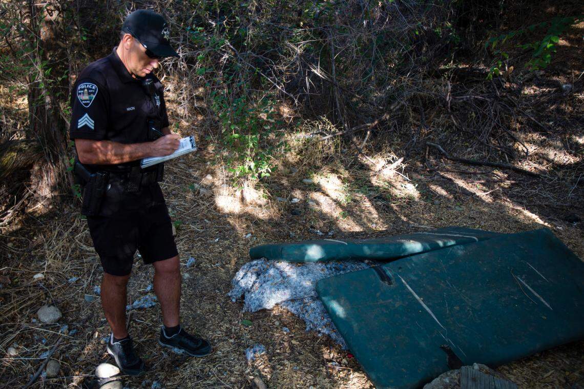 Sgt. Craig Nixon of the Boise Police Department’s Micro District Bike Patrol writes up a “Notice of Clean-Up and Removal” in a corner of Ann Morrison Park.