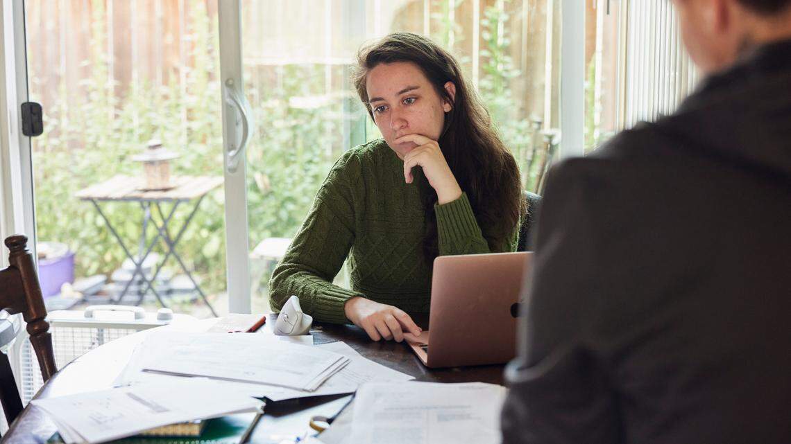 Emily Carter, left, and Kieria Krieger now live together in Portland where their home is buried in documents from their yearslong fight.