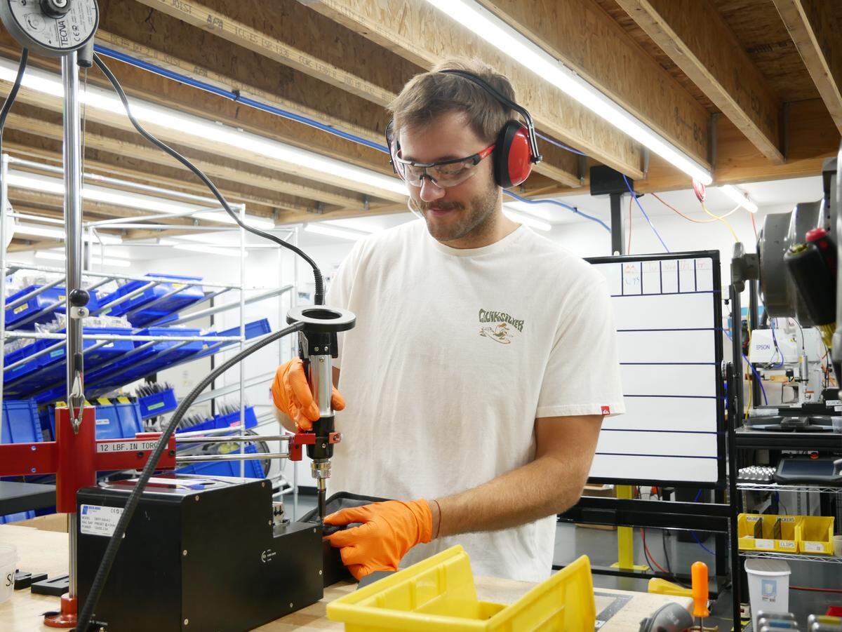 At Holstery, a tool belt manufacturer in Moscow, Nick Butler uses a torque driver to screw belt clips onto tool holsters. President Trump’s tariffs have increased CEO Josh Hartung’s desire to bring more manufacturing processes in-house, but they also pose challenges.