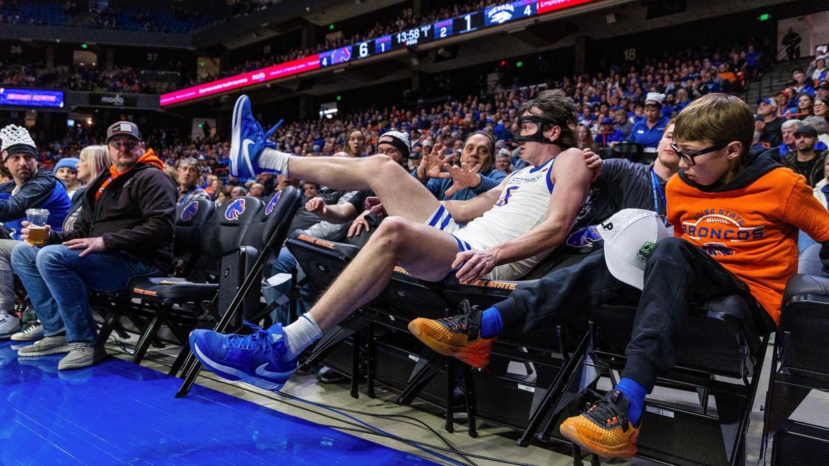 Boise State forward RJ Keene II makes a leaping save near the baseline and lands in seats next to fans in a game against Nevada last season.