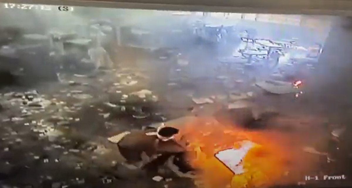 A man inside H-Block, Tier 1 of the Idaho State Correctional Center throws items onto an open fire during an incident inside the prison on April 10, 2021.