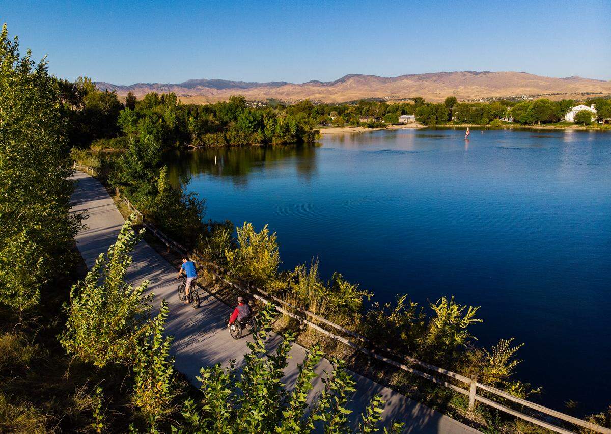 Two individuals travel along the Greenbelt by Quinn’s Pond in Garden City on Sept. 24, 2022.